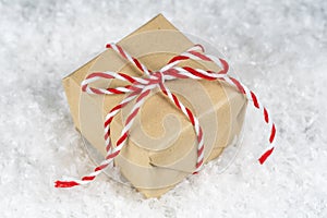 Hand wrapped plain paper small gift box tied with red and white