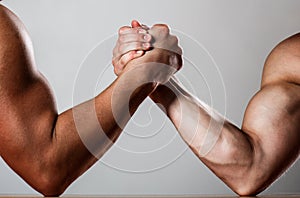 Hand wrestling, compete. Hands or arms of man. Muscular hand. Clasped arm wrestling. Two men arm wrestling. Rivalry