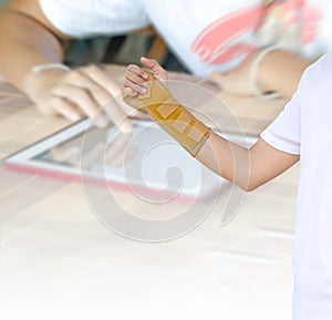 Hand with a wrist brace on blurred background hands using modern