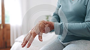 Hand, wrist pain or arthritis with a senior on the bed in a home for recovery from injury closeup. Anatomy, osteoporosis