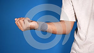 hand with wrist support against blue background.