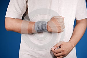 hand with wrist support against blue background.
