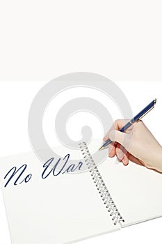 Hand writes the inscription `No war` with a pen in a notebook