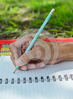 hand writes a pen in a notebook