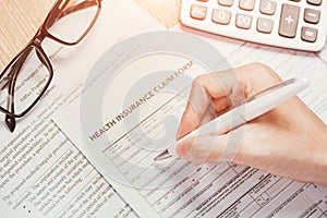 Hand writes the personal information on the health insurance claim form