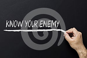 Hand writing on blackboard - know your enemy photo