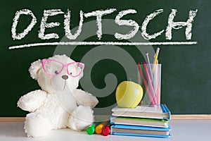 Hand writing on a blackboard in a language class for children with the word `English` writen on.