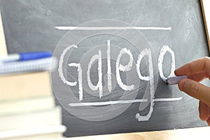 Hand writing on a blackboard in a language class with the word GALICIAN wrote on.