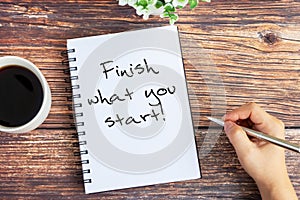Hand writing Finish what you start! text on notepad