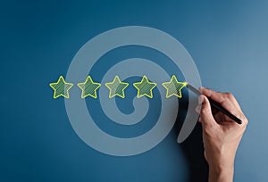 Hand writing five stars for customer feedback and evaluation in experience service and product. Excellent rating. User give rating