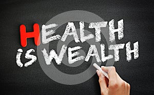 Hand writing Health is Wealth on blackboard, health concept background