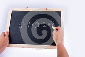 Hand writing a math problem on board