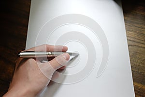 Hand writing with pen over blank paper on wooden work desk beautiful pattern,concept of idea and actions,Hand holding for pen,Work