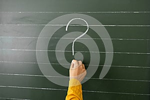 Hand writing question marks on the background of boards.