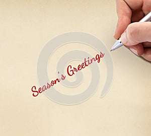 Hand writing `Season`s Greetings `