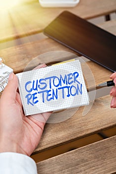 Hand writing sign Customer Retention. Business approach activities companies take to reduce user defections