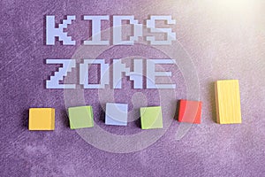 Hand writing sign Kids Zone. Business idea An area or a region designed to enable children to play and enjoy Stack of