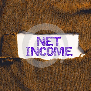 Hand writing sign Net Income. Concept meaning the gross income remaining after all deductions and exemptions are taken