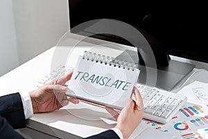 Hand writing sign Translate. Business approach Another word with same equivalent meaning of a target language photo
