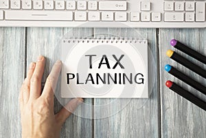 Hand writing Tax Planning word on the accountant