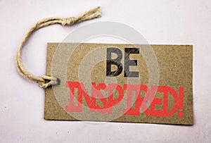 Hand writing text caption inspiration showing Be Inspired. Business concept for Inspiration, Motivation written on price tag paper