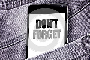 Hand writing text caption inspiration showing Do Not Forget. Business concept for Don t memory Remider written mobile cell phone w photo