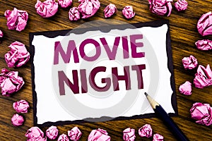 Hand writing text caption inspiration showing Movie Night. Business concept for Wathing Movies Written on sticky note paper, wood