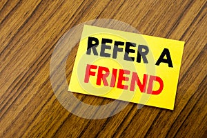 Hand writing text caption inspiration showing Refer A Friend. Business concept for Referral Marketing written on sticky note paper