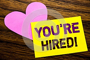 Hand writing text caption inspiration showing You Are Hired. Business concept for Hiring Employee Worker written on sticky note pa