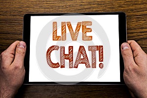 Hand writing text caption Live Chat . Business concept for Communication Livechat Written on tablet laptop, wooden background with photo