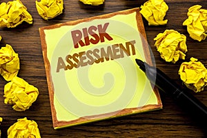 Hand writing text caption showing Risk Assessment. Business concept for Safety Danger Analyze Written on sticky note paper, wooden