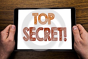 Hand writing text caption Top Secret. Business concept for Military Top Secret Written on tablet laptop, wooden background with bu