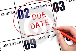 Hand writing text DUE DATE on calendar date December 2 and circling it. Payment due date