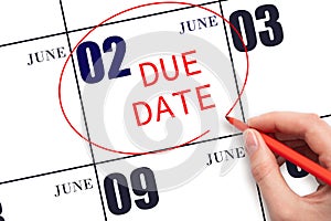 Hand writing text DUE DATE on calendar date June 2 and circling it. Payment due date