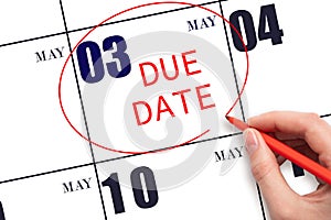 Hand writing text DUE DATE on calendar date May 3 and circling it. Payment due date
