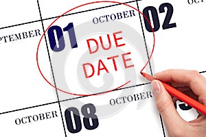 Hand writing text DUE DATE on calendar date October 1 and circling it. Payment due date