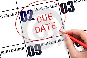 Hand writing text DUE DATE on calendar date September 2 and circling it. Payment due date