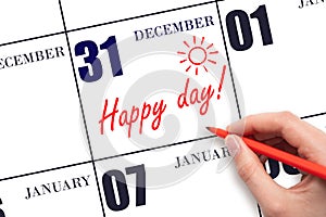 Hand writing the text HAPPY DAY and drawing the sun on the calendar date December 31