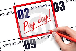 Hand writing text PAY DATE on calendar date November 2 and underline it. Payment due date