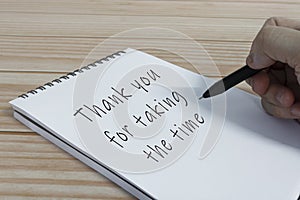 Hand writing thank you for taking the time text on notepad.