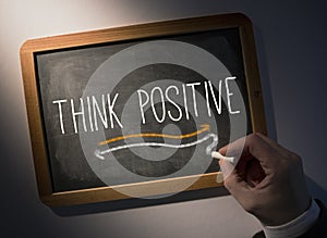 Hand writing Think positive on chalkboard