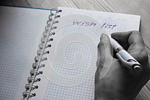 Hand writing unfocused wish list in notebook in cell black and white. New Years planning concept. Business and office concept.