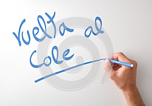 Hand writing vuelta al cole on white board