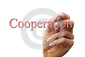 Hand writing the word cooperation