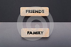 Hand writing word friend and family text on wooden board.