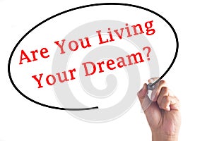 Hand writing Are You Living Your Dream? on transparent board