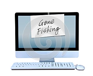 Hand written Gone Fishing sign taped to computer