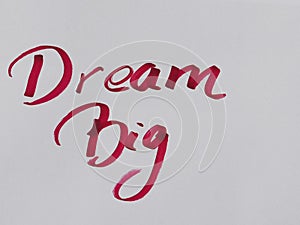 Hand written text Dream big on white paper