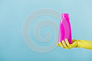 Hand in yellow glove holds a bottle of bleach on white background. cleaning