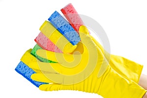 A hand in a yellow glove holds a set of sponges isolated on a white background. Close-up